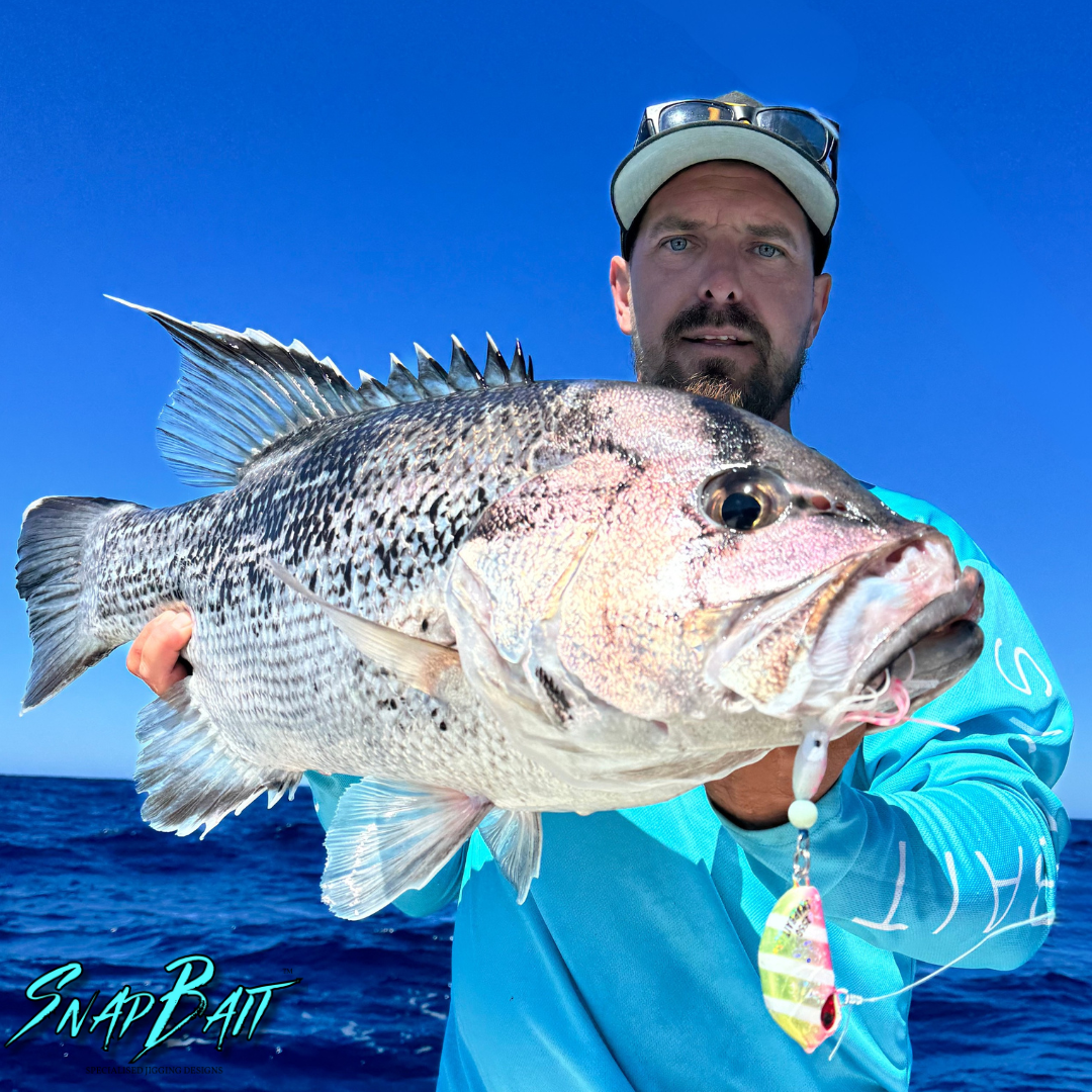Angler holding a large fish caught using SnapBait Australia Hybrid Jigs fishing lure on the ocean